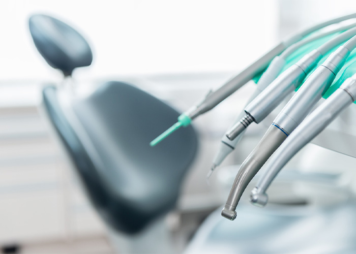 dental tools with a dental chair in the background