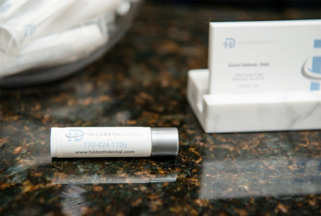 chapstick with Hildreth Dental phone number and website on the front desk counter